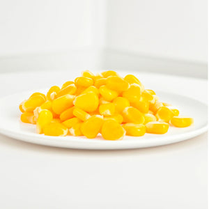 Fresh yellow sweet corn kernels on a white plate, plant-based food from iPlantBased UAE