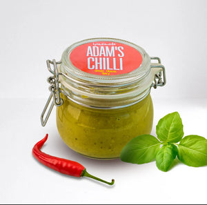 Glass jar labeled Adam's Chilli with green sauce, red chili pepper, and basil leaves, plant-based.