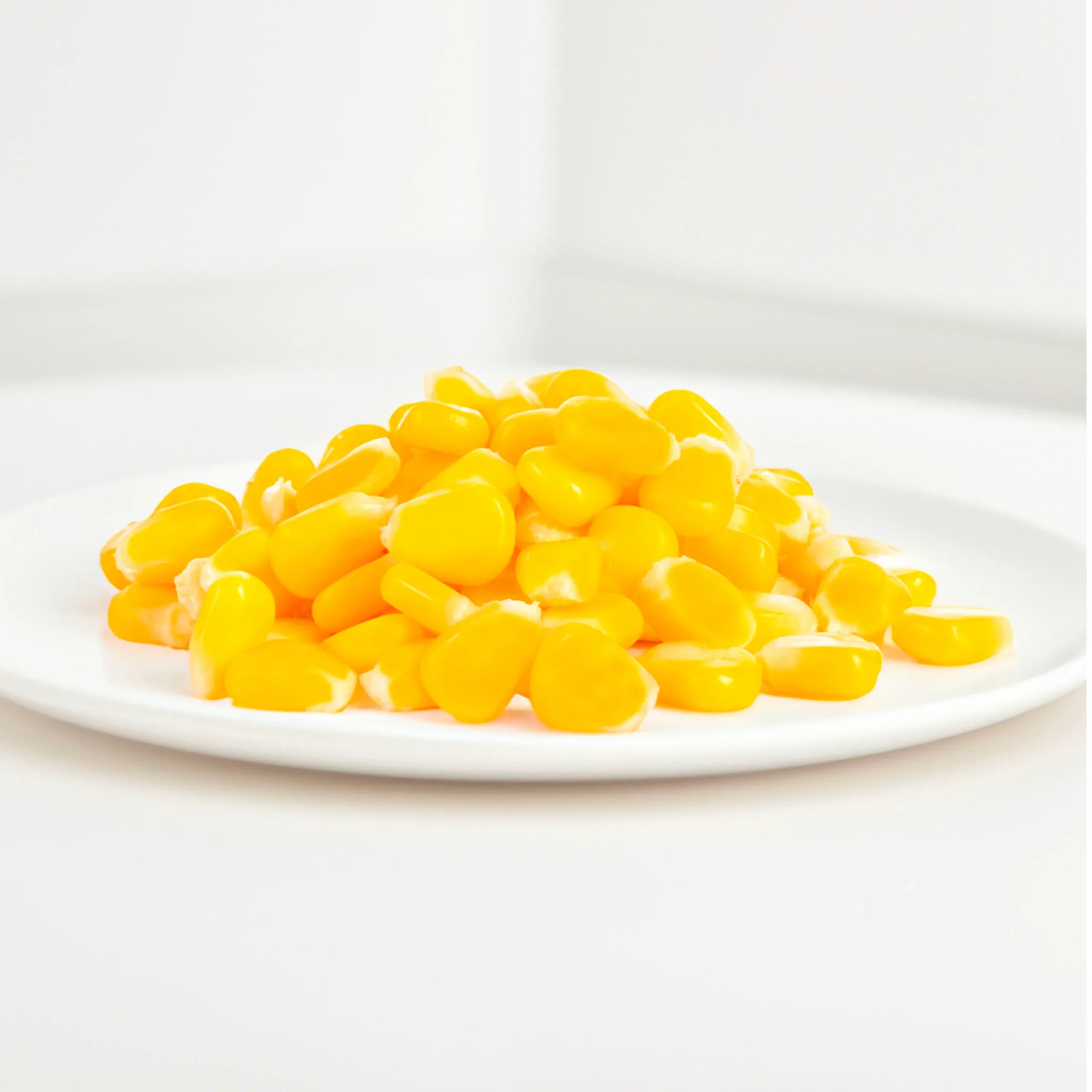 Fresh yellow sweet corn kernels on a white plate, plant-based food from iPlantBased UAE